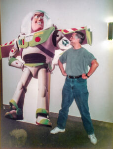 Stan Deneroff posing next to Buzz Lightyear.